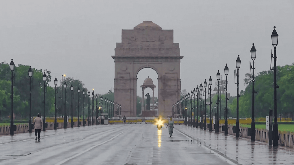 Car drives through rain near India Gate in Delhi. 