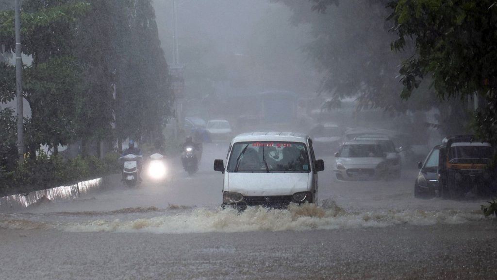 Vehicles wade through a waterlogged road at Andheri West, Mumbai