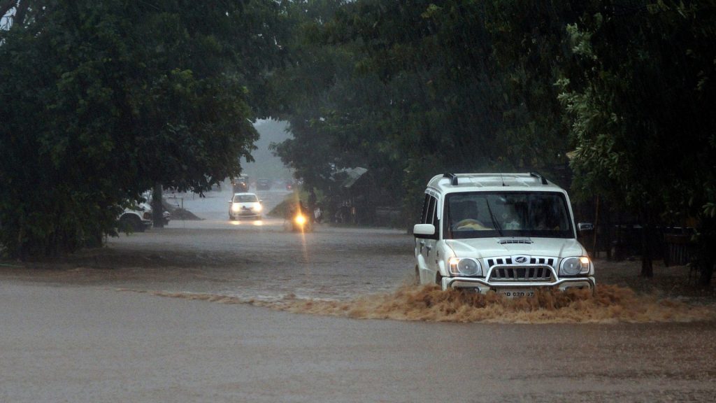 Vehicles ply on a water-logged street during heavy rains, in Bhubaneswar