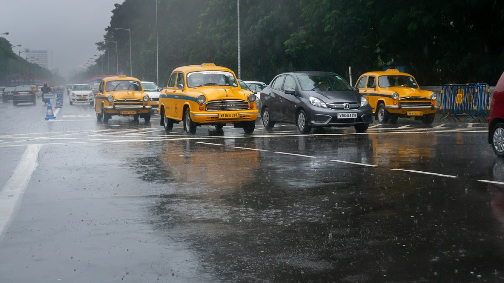 Vehicles move through heavy rain on a Kolkata road