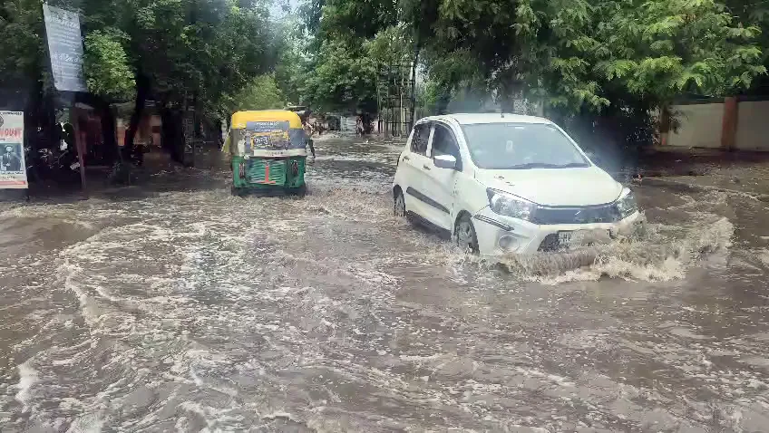 Gurugram: Vehicles move through a waterlogged area amid rainfall, in Gurugram on Sunday. (ANI Video Grab)