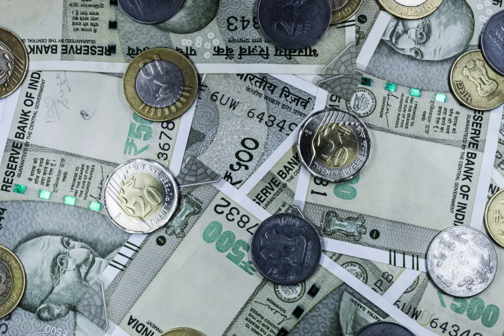 Top view of various Indian rupee banknotes and coins