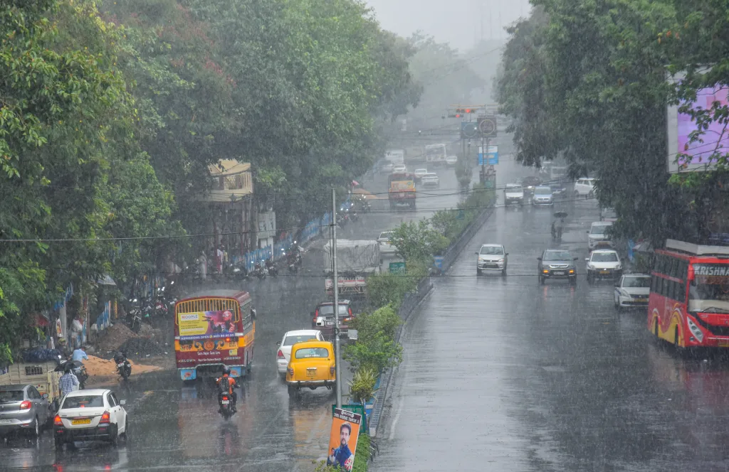 Vehicles ply on a road amid rain in Kolkata