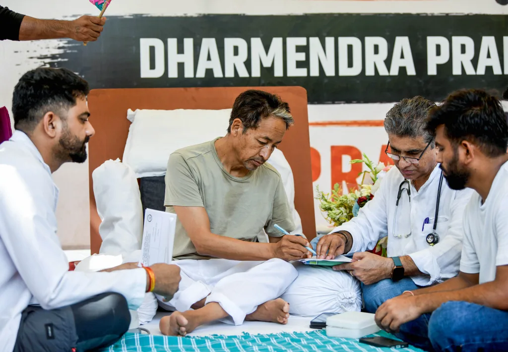 Environmentalist Sonam Wangchuk being attended by medical professionals on the 18th day of his indefinite hunger strike during the Cockroach Janata Party's (CJP) protest, demanding the Union Education Minister Dharmendra Pradhan's resignation over alleged irregularities in the NEET examination, at Jantar Mantar, in New Delhi on Wednesday. CJP founder Abhijeet Dipke present. (ANI Photo/Rahul Singh)