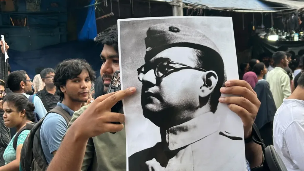 A protestor holding a photo of Netaji Subhas Chandra Bose