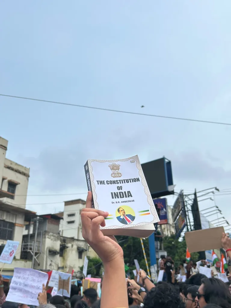 A protester holding a copy of the Indian Constitution at the rally
